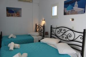 two beds in a room with blue and white at Spiridoula Villa - Santorini Seaside Retreats in Perissa