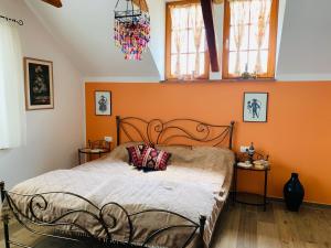 a bedroom with a bed with an orange wall at STATUS Apartments in Bled