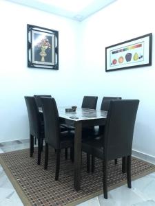 a dining room with a table and black chairs at Pinggiran Homestay in Batu Caves