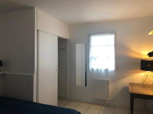 Un dormitorio con una cama, una ventana y un espejo. en La terrasse honfleuraise, en Honfleur