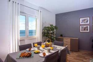 a dining room with a table with food and drinks at VILLA MASLINA, with private 32m2Pool, panoramic views on 100km coastline, 12 pax in Lokva Rogoznica