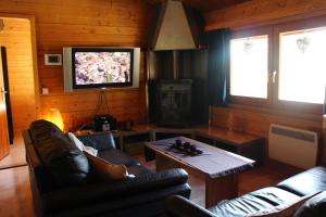 uma sala de estar com um sofá e uma televisão em Chalet Dennerust - The Original em Durbuy