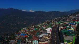 an aerial view of a city with buildings and mountains at Yangthang Heritage in Gangtok