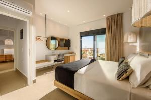 a bedroom with a bed and a desk and a window at Calma Villas Crete - heated pool in Sissi +147 photos