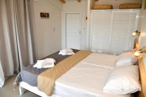 カボスにあるCavos Beach Houseのベッドルーム1室(ベッド1台、タオル2枚付)