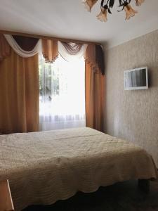 ein Schlafzimmer mit einem Bett und einem großen Fenster in der Unterkunft P. Stradiņa iela 17 Апартаменты in Ventspils