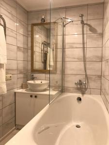 La salle de bains est pourvue d'une baignoire blanche et d'un lavabo. dans l'établissement P. Stradiņa iela 17 Апартаменты, à Ventspils