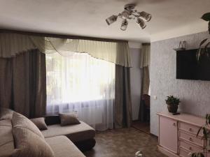 a living room with a couch and a window at P. Stradiņa iela 17 Апартаменты in Ventspils
