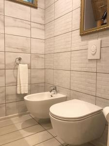 a white bathroom with a toilet and a sink at P. Stradiņa iela 17 Апартаменты in Ventspils