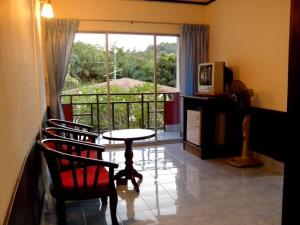 sala de estar con mesa, sillas y ventana en Phi Phi View Point Resort en Phi Phi Don