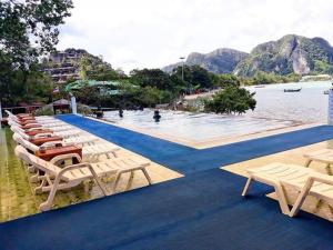 a group of lounge chairs and a swimming pool at Phi Phi View Point Resort in Phi Phi Islands