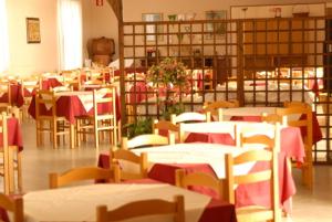 a room full of tables and chairs with red table cloth at Santa Caterina in San Vincenzo