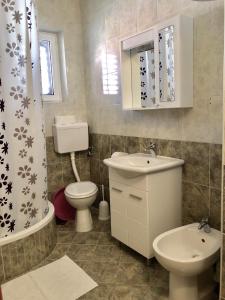 ein Badezimmer mit Waschbecken, Toilette und Dusche in der Unterkunft Apartment DAZ in Makarska