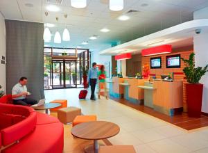 a lobby of a fast food restaurant with people working at Ibis Warszawa Reduta in Warsaw