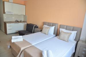 a hotel room with two beds and a chair at Helada Apartments in Tivat