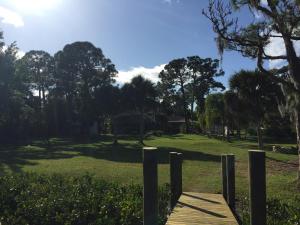 a wooden boardwalk in a park with trees and grass at Water FUN! poolPIERkayaksCANOE MotorBoatRENTALpets in Englewood