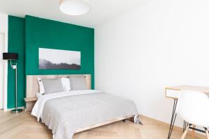 een slaapkamer met een groene accentmuur en een bed bij Nest - Badenerstrasse 356 in Zürich