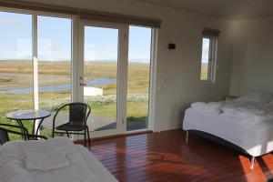 um quarto com 2 camas, uma mesa e cadeiras em Holssel road 864 em Myvatn