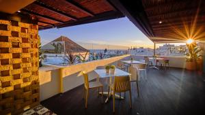 un restaurant avec des tables et des chaises sur un balcon dans l'établissement Hostal Campito, à Conil de la Frontera