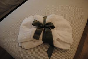 - une serviette blanche avec une étrave noire sur un lit dans l'établissement DolceLago, à Sirone