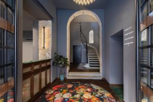 a hallway with a spiral staircase and a circular rug at Chapter Roma in Rome