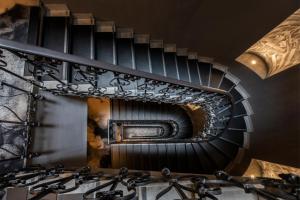a spiral staircase with a round mirror above a sink at Chapter Roma in Rome