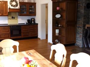 a kitchen with a table and chairs and a clock at Ferienwohnung Elisabeth Eifel in Mosbruch +13 photos