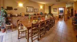 ALBERGUE SAN SATURNINO في Ventosa: غرفة طعام مع طاولة وكراسي خشبية كبيرة
