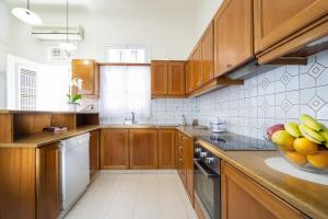 una cocina con armarios de madera y un bol de fruta en la barra en Metropolis House, en La Canea