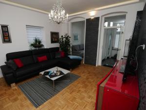 ein Wohnzimmer mit einer schwarzen Couch und einem Tisch in der Unterkunft Küstenwilla FeWo Usedom in Zinnowitz
