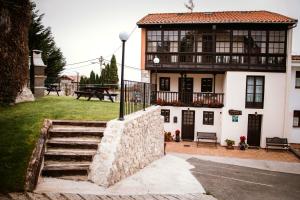 a house with a staircase in front of it at El Requexu, apartamentos a 900 m de la playa de Poo in Llanes