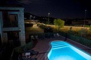 a swimming pool in front of a house at night at GF Apartments La Vigna in Badesi