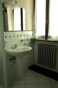 a white bathroom with a sink and a radiator at Residenza Italia in Casteldelfino