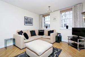 ein Wohnzimmer mit einem Sofa und einem TV in der Unterkunft West Bow - Comfy 2 bed on West Bow overlooking Grassmarket in Edinburgh