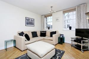 a living room with a couch and a tv at West Bow - Comfy 2 bed on West Bow overlooking Grassmarket in Edinburgh