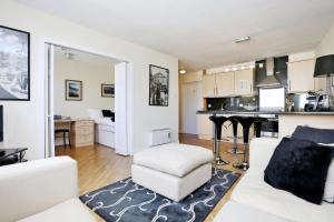 uma sala de estar com um sofá branco e uma cozinha em West Bow - Comfy 2 bed on West Bow overlooking Grassmarket em Edimburgo