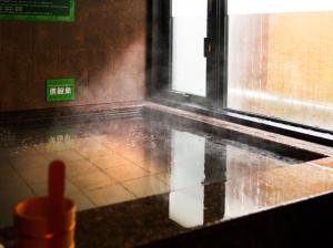 a room with rain on the floor and a window at Super Hotel Tokyo Kinshicho Ekimae in Tokyo