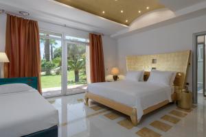 a bedroom with two beds and a large window at Grande Dame Villa of Rhodes in Rhodes Town