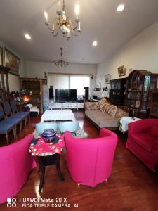 鹿谷的住宿－溪頭紅瓣天民宿，客厅配有粉色家具和吊灯。
