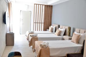 a hotel room with three beds with towels on them at Helada Apartments in Tivat