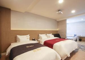 a hotel room with two beds in a room at No.1 New Yorker Hotel in Jinju