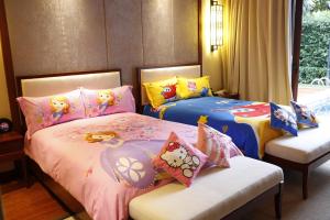 two beds with hello kitty pillows in a bedroom at Sanya Ocean Sonic Banling Hotspring Resort in Sanya