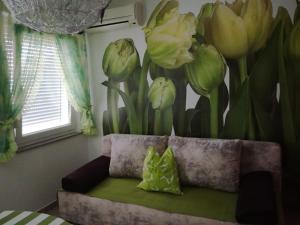 a mural of flowers on a wall next to a couch at Apartment Ksenija in Crikvenica