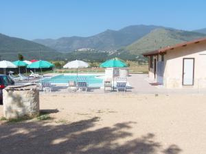 una piscina con tavoli, sedie e ombrelloni di Aecolibrium Country House a Pastena