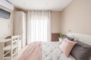 a white bedroom with a bed and a window at Hostal Buenos Aires in Tremp