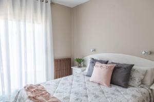 een witte slaapkamer met een bed met kussens bij Hostal Buenos Aires in Tremp