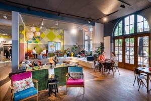 ein Restaurant mit Leuten, die an Tischen in einer Cafeteria sitzen in der Unterkunft Stayokay Hostel Amsterdam Oost in Amsterdam