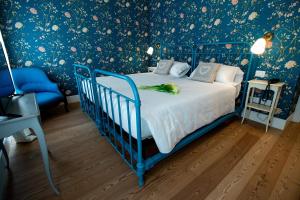 una culla blu in una camera da letto con carta da parati floreale di Locanda Capolago a Colico