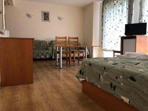 a bedroom with a bed and a table and chairs at Family Hotel Central in Kranevo