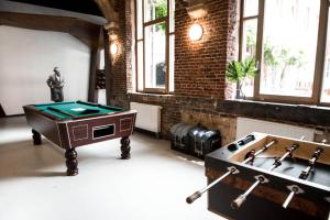 una camera con tavolo da biliardo e piano cottura di Liège Youth Hostel a Liegi